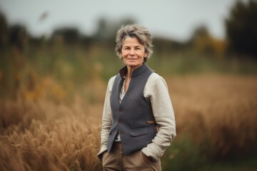 Portrait of a happy senior woman standing in a wheat field.