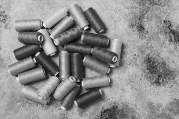 Sewing threads on bobbins. On a black and white background. Place for text.