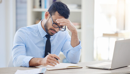 Obraz premium When inspiration refuses to come. a young businessman experiencing a headache at work.