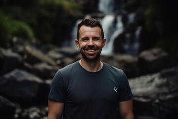 Portrait Of Happy Man Smiling To Camera Against Waterfall Background