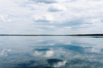 Summer lake background. Small forest pond landscape. Holiday in rural Poland. Cloudy day view. Simple water surface. Empty landscape water reflection. Tranquility cloudscape. Fishing location.