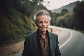 Portrait of a happy senior man on a road in the countryside