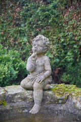 Fototapeta na wymiar Romantic garden fountain with a boy figure.