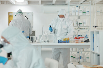 Conducting experiments under defined conditions. a scientist wearing a radiation suit while working with samples in a lab.
