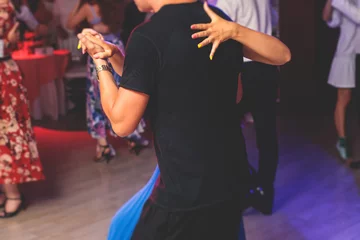 Fotobehang Dansschool Couples dancing traditional latin argentinian dance milonga in the ballroom, tango salsa bachata kizomba lesson in the red and purple lights, dance school class festival