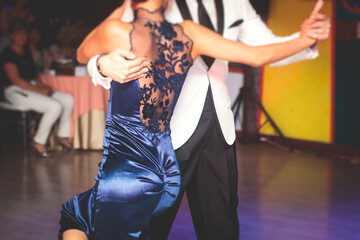 Couples dancing traditional latin argentinian dance milonga in the ballroom, tango salsa bachata kizomba lesson in the red and purple lights, dance school class festival