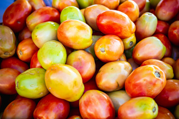 Several tomatoes at a street market for sale.