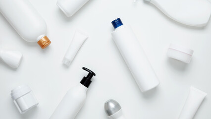Cosmetic beauty products on white background. Bottles and tubes with branding mock up. Skin care and beauty concept. Top view, flat lay, copy space