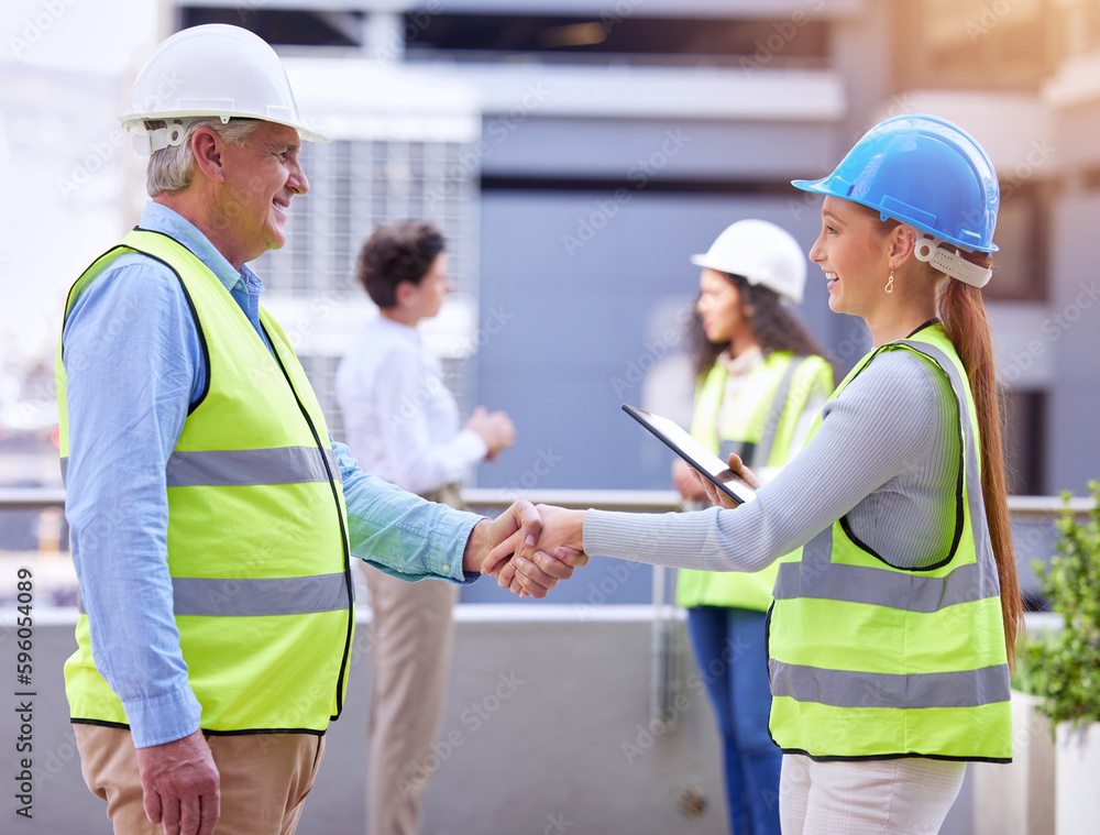 Poster Ready for the electrical. two construction workers shaking hands while standing on a building site.