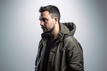 Obraz premium Young man in a jacket on a gray background. Studio shot.