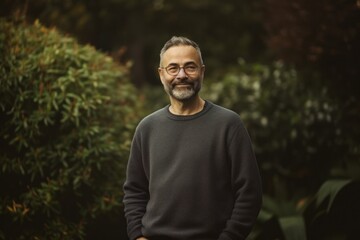 Portrait of a handsome mature man with a beard in a park