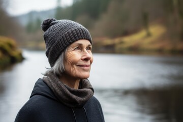 Portrait of a happy senior woman standing in front of a river