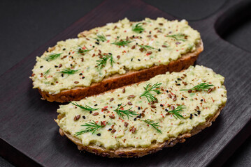 Grilled toast with avocado paste, eggs, cream cheese, salt, spices and herbs