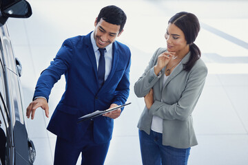 This one has some really nice finishes. a handsome young male car salesman talking to a female...