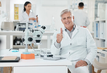 Its all good here. Portrait of a senior scientist showing thumbs up while working in a lab.
