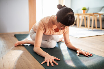 Fototapeta na wymiar Young Japanese woman doing yoga at home