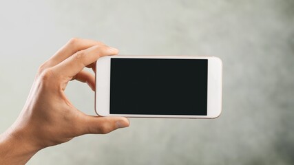 Hand holding phone with a blank screen