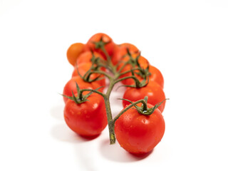 Bunch of fresh red tomatoes with green stems isolated on white background.