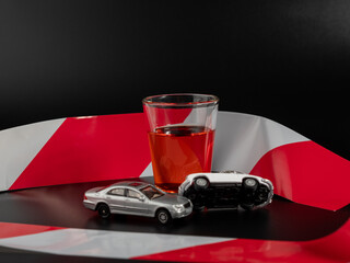Mini car accident. Alcohol and a toy car on a black background.