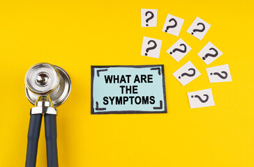 On a yellow background, a stethoscope, question marks and a sticker with the inscription - What are the symptoms