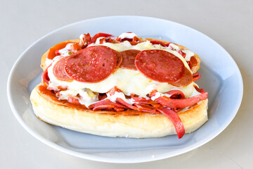 Close-up shot of Izmir's famous Turkish Traditional Kumru Sandwich, Çeşme Kumru , ingredients ready to eat salami, sucuk , tomato, cheddar cheese and fried cheese. Yengen eritme karisik sandvic.