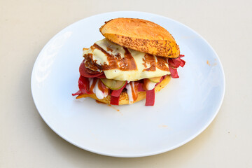 Close-up shot of Izmir's famous Turkish Traditional Kumru Sandwich, Çeşme Kumru , ingredients ready to eat salami, sucuk , tomato, cheddar cheese and fried cheese. Yengen eritme karisik sandvic.