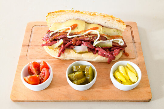 Close-up shot of Izmir's famous Turkish Traditional Kumru Sandwich, &Ccedil;eşme Kumru , ingredients ready to eat salami, sucuk , tomato, cheddar cheese and fried cheese. Yengen eritme karisik sandvic.
