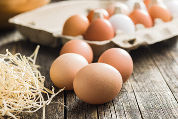 Whole chicken eggs on wooden table.