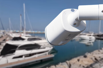 Pair of outdoor security cameras in yachting harbor.