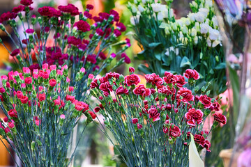 Fototapeta na wymiar Świeże cięte kwiaty wystawione na straganie na hali targowej. 