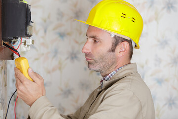 electrician measuring voltage in distribution board closeup