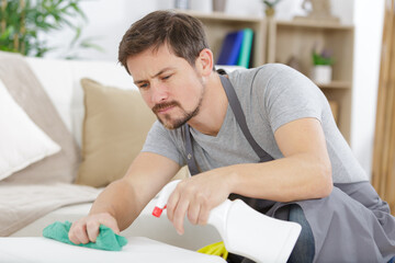 man spraying sofa house service