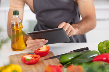 cropped view of man cooking and using digital tablet