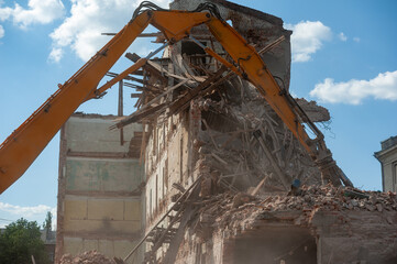 Demolition of building. Excavator breaks old house. Freeing up space for construction of new...