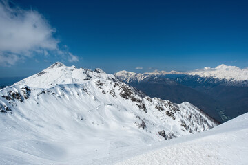 Fototapeta premium Beautiful snow capped peaks of the Caucasus Mountains. Rosa Khutor Alpine Resort in Sochi. Russia