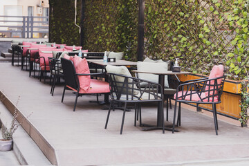 Fototapeta na wymiar Cafe table and chairs on urban street - summer restaurant and coffee shop outdoor concept