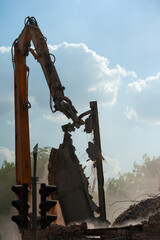 Demolition of building. Excavator breaks old house. Freeing up space for construction of new building