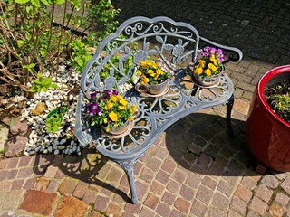 Blumen auf der Bank im Vorgarten