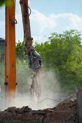 Demolition of building. Excavator breaks old house. Freeing up space for construction of new building