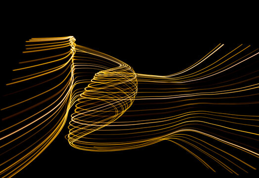 Abstract lights of golden colors forming patterns of curved lines. Festive decoration.