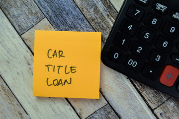 Concept of Car Title Loan write on sticky notes with calculator isolated on Wooden Table.