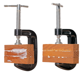 Small wood clamp with glued material. Three pieces of wood held together with carpenter's glue in a metal clamp. Isolated background.