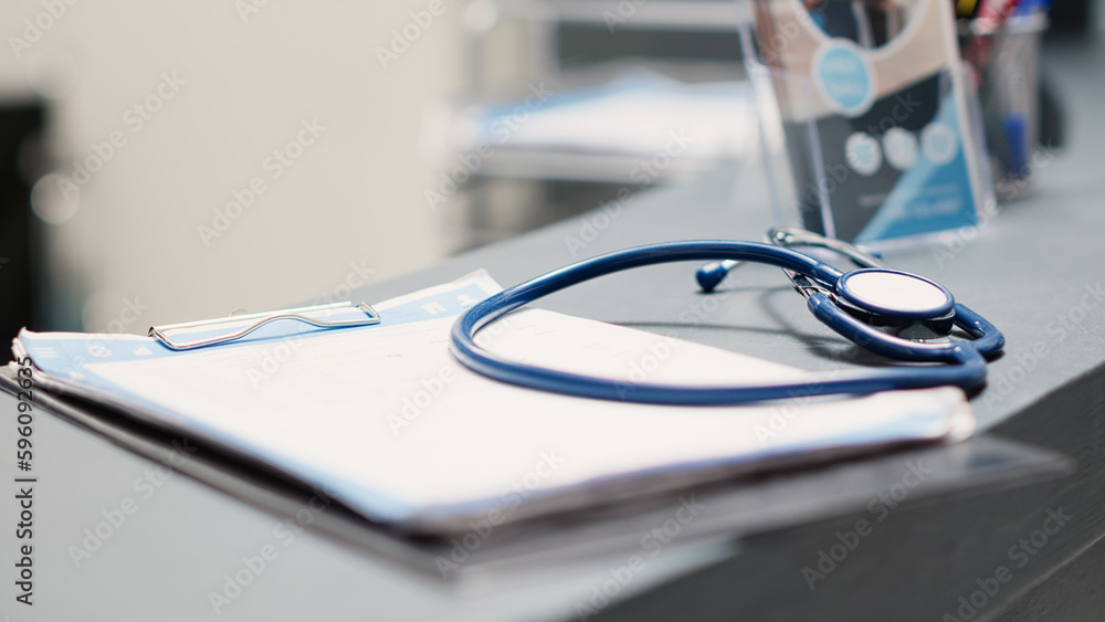 Poster papers and stethoscope on front desk, registration forms used to help with insurance service and med