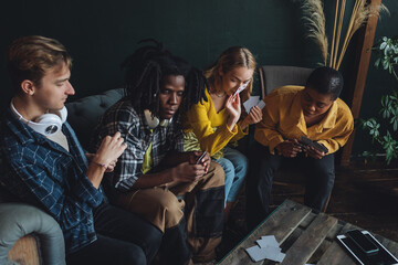 Diverse group of young people, friends, college students gathering together, have fun, playing games, laughing. Concept of diversity, international friendship, learning foreign languages, university