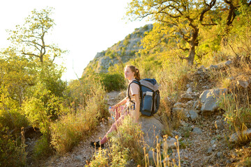 Young woman hiking in countryside. Concepts of adventure, extreme survival, orienteering. Backpacking hike