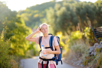 Young woman hiking on mountains in Europe. Concepts of adventure, extreme survival, orienteering. Backpacking hike