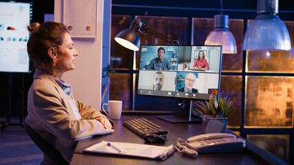 Female worker attending corporate meeting remote using teleconference and webcam on pc, talking to...