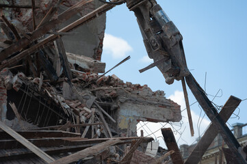 Demolition of building. Excavator breaks old house. Freeing up space for construction of new building