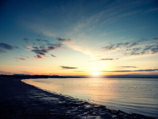 Silhouette of a rough coastline at sunrise. Warm and cool color. Nobody. Stunning nature scene. Galway bay, Ireland.