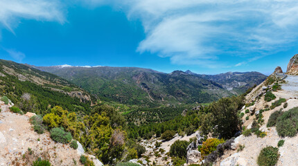 Summer mountain landscape with snow on peak and road (Sierra Nevada National Park, near Granada, Spain).